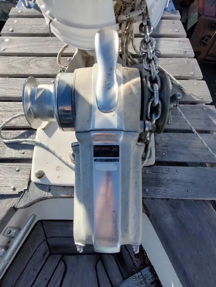 Slide: The Image of Vintage 1977 Hallberg-Rassy 41 sailboat winch with chain on wooden deck. - 23