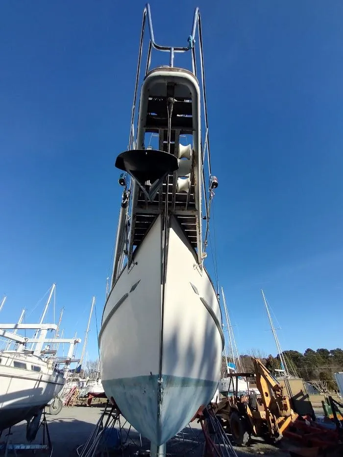 Slide: The Image of 1977 Hallberg-Rassy 41 sailboat on dry dock, viewed from the bow under a clear blue sky. - 3