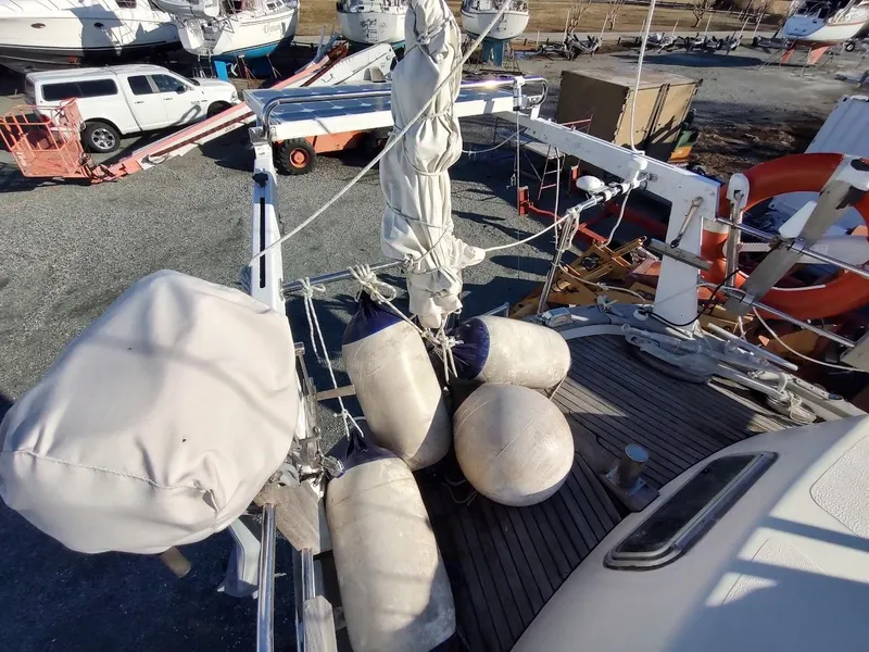 Slide: The Image of 1977 Hallberg-Rassy 41 sailboat deck with fenders and rigging in a boatyard. - 30