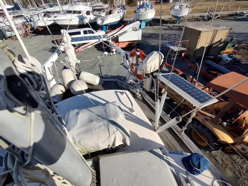 Slide: The Image of 1977 Hallberg-Rassy 41 sailboat on land, surrounded by other boats and equipment. - 32