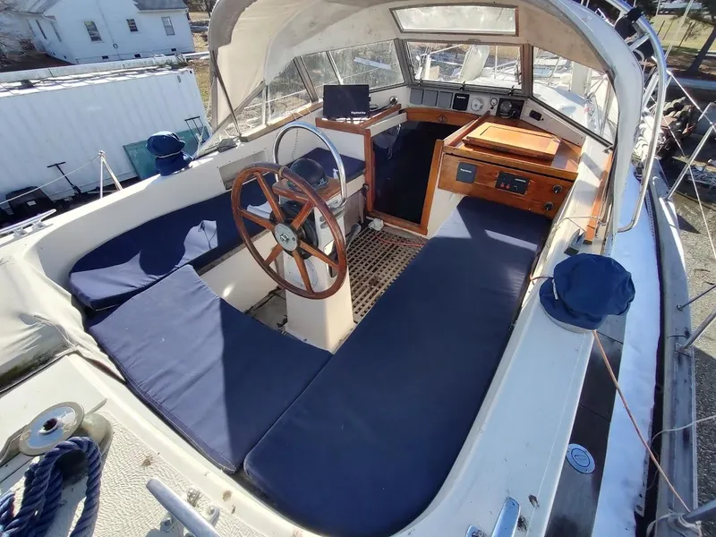 Slide: The Image of 1977 Hallberg-Rassy 41 sailboat cockpit with wooden wheel and blue cushions. - 36