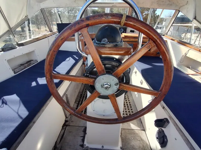 Slide: The Image of 1977 Hallberg-Rassy 41 sailboat cockpit with wooden steering wheel and blue seating. - 37