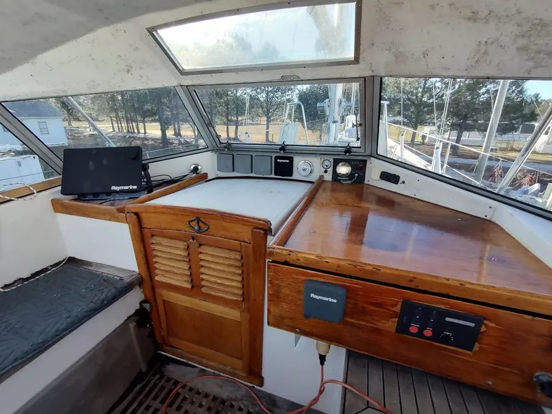 Slide: The Image of 1977 Hallberg-Rassy 41 yacht cockpit with wooden paneling and navigation equipment. - 41