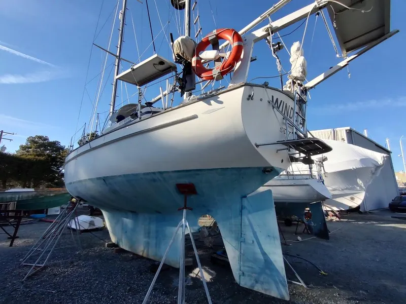Slide: The Image of 1977 Hallberg-Rassy 41 sailboat on dry dock, with blue hull and lifebuoy. - 6