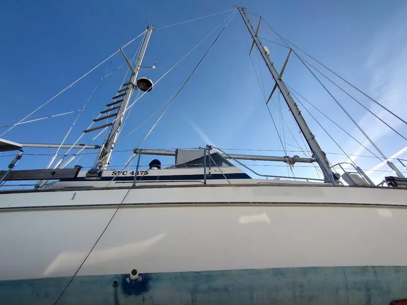 Slide: The Image of 1977 Hallberg-Rassy 41 sailboat with tall masts against a clear blue sky. - 8