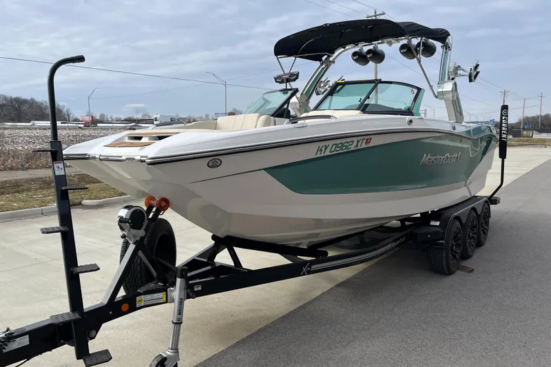 Slide: The Image of 2022 MasterCraft X24 boat on trailer, parked outdoors, showcasing sleek design and modern features. - 4