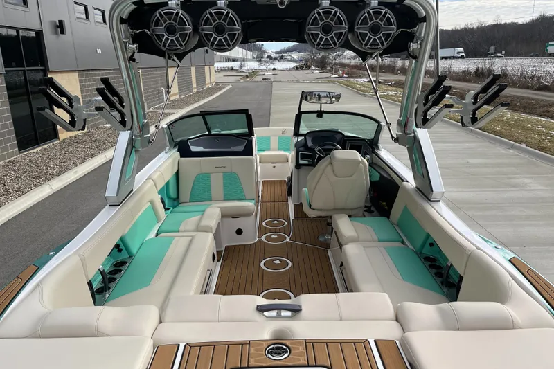 Slide: The Image of 2022 MasterCraft X24 boat interior with teal and beige seating, premium audio system, and sleek design. - 9