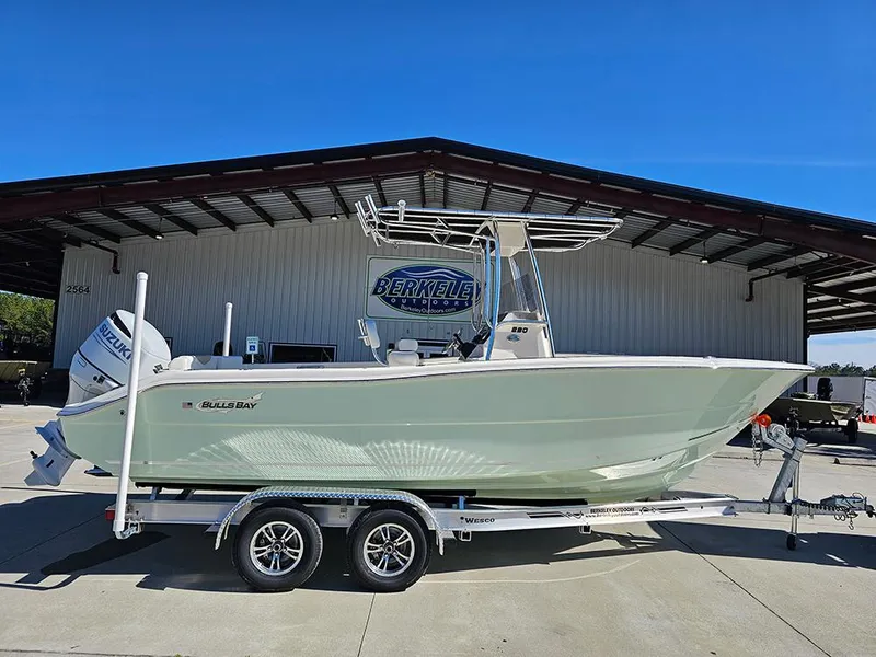 The Image of 2025 Bulls Bay 230 CC boat on trailer, parked outside a metal building. - 1