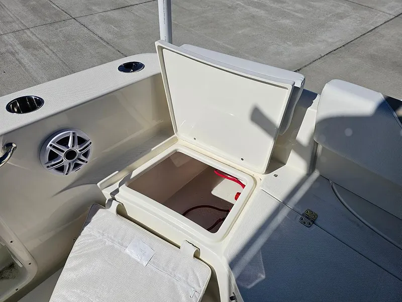 Slide: The Image of 2025 Bulls Bay 230 CC boat interior with open storage compartment and speaker. - 15
