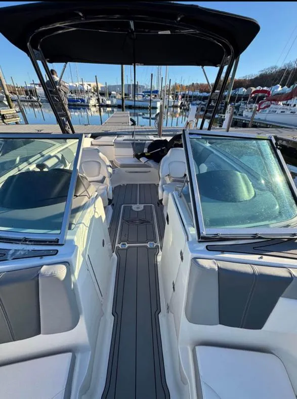 Slide: The Image of 2021 Chaparral 23 SSi boat docked at marina, featuring sleek design and spacious seating. - 5