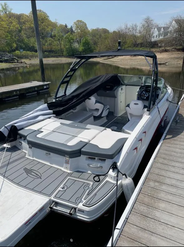 Slide: The Image of 2021 Chaparral 23 SSi boat docked, featuring sleek design and spacious seating. - 9