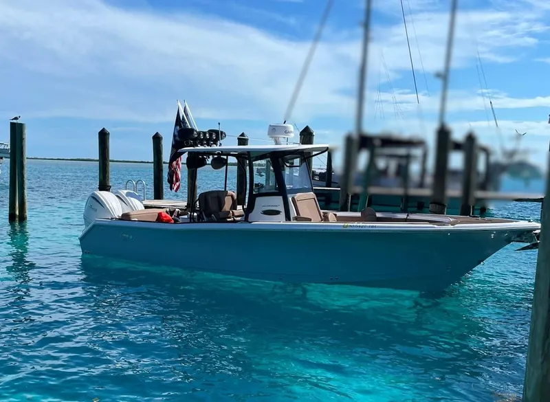 Slide: The Image of 2022 Sea Hunt Ultra 305 SE boat docked in clear blue water. - 1