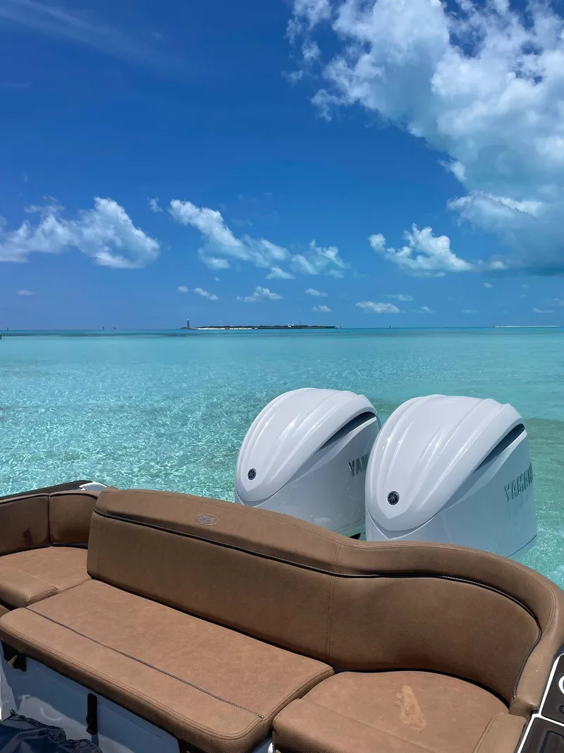 Slide: The Image of Sea Hunt Ultra 305 SE 2022 boat with twin engines on clear turquoise water. - 22