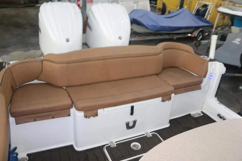 Slide: The Image of 2022 Sea Hunt Ultra 305 SE boat with brown cushioned seating and dual outboard motors. - 6