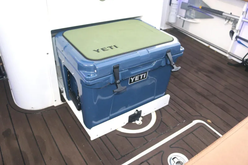 Slide: The Image of YETI cooler on 2022 Sea Hunt Ultra 305 SE boat deck, featuring wood flooring. - 7