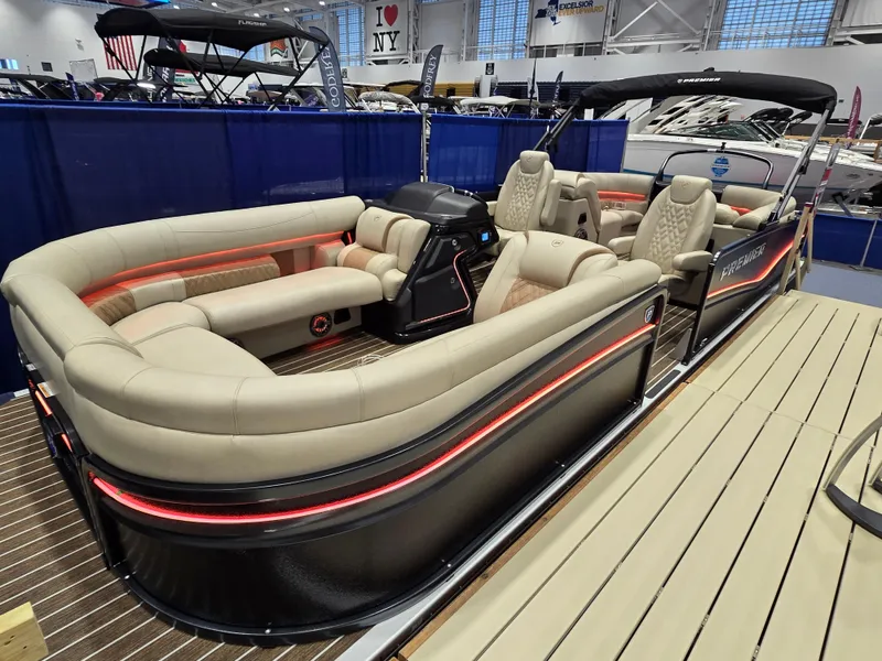 The Image of Luxurious 2025 Premier Intrigue pontoon boat with plush seating and modern design at a boat show. - 0