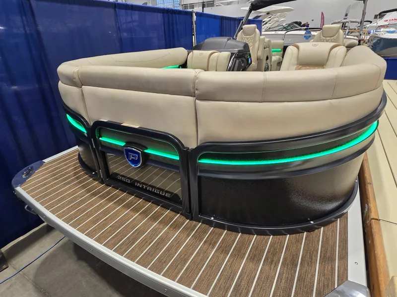 Slide: The Image of Premier Intrigue 2025 pontoon boat with beige seating and green LED lights. - 1