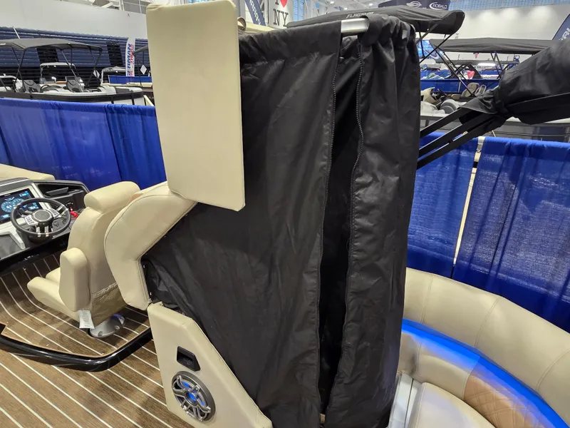 Slide: The Image of 2025 Premier Intrigue boat interior with black privacy curtain and beige seating. - 17