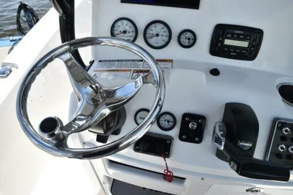Slide: The Image of 2022 NauticStar 2302 Legacy boat dashboard with steering wheel and gauges. - 10
