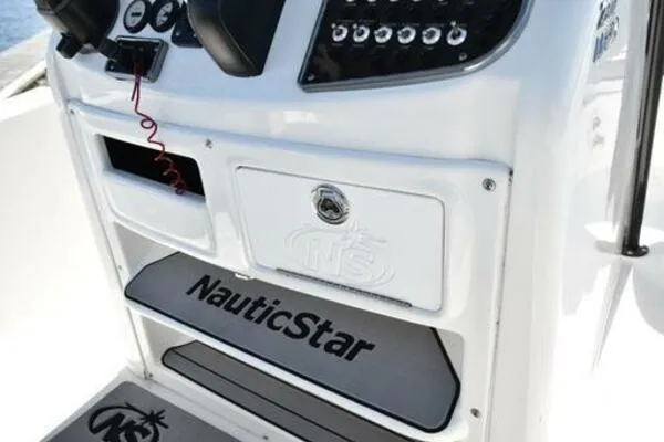 Slide: The Image of NauticStar 2302 Legacy 2022 boat console with controls and branding. - 12