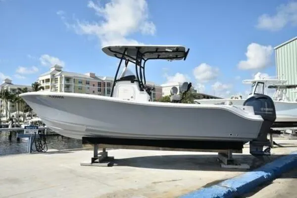 Slide: The Image of 2022 NauticStar 2302 Legacy boat docked, featuring sleek design and modern amenities. - 2