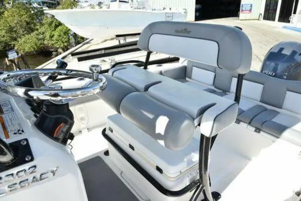 Slide: The Image of 2022 NauticStar 2302 Legacy boat interior with steering wheel and seating. - 9