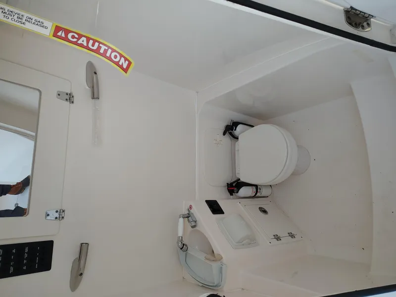 Slide: The Image of 2020 Cobia 240 Center Console boat interior with toilet and sink. - 19
