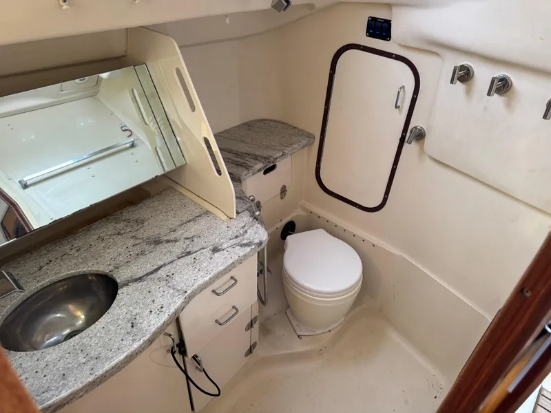 Slide: The Image of 2000 Hunter 340 yacht bathroom with granite countertop, mirror, and compact toilet. - 5