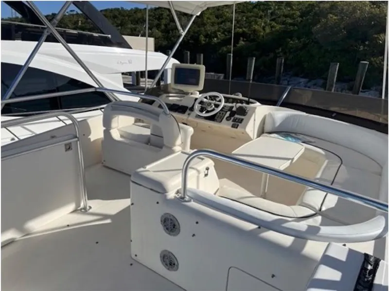 Slide: The Image of 1998 Viking Sports Cruiser with spacious cockpit and modern helm, docked near lush greenery. - 25