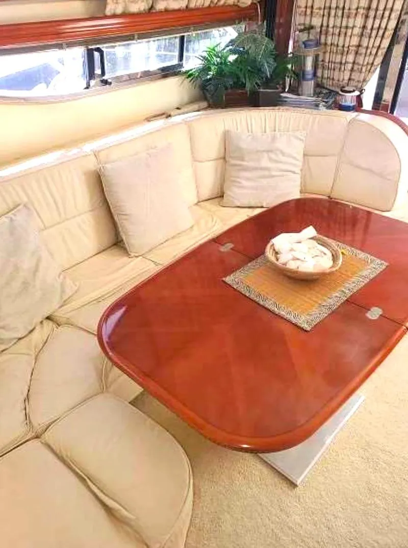 Slide: The Image of Luxurious interior of a 1998 Viking Sports Cruiser with plush seating and elegant wooden table. - 26