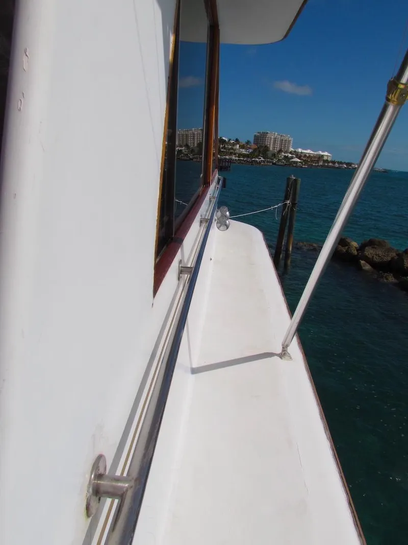 Slide: The Image of 1972 Hargrave 67 Motor Yacht deck view with ocean and cityscape background. - 16