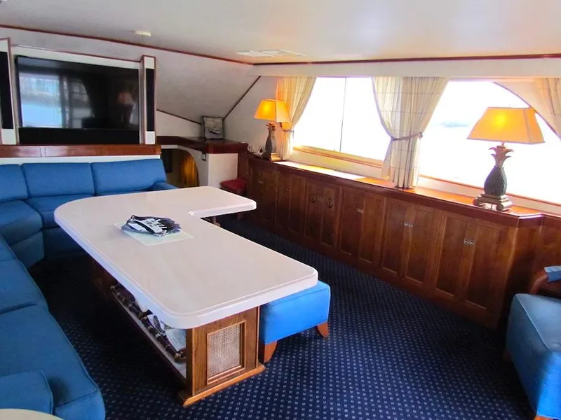 Slide: The Image of Luxurious interior of 1972 Hargrave 67 Motor Yacht with blue seating and elegant wood finishes. - 21