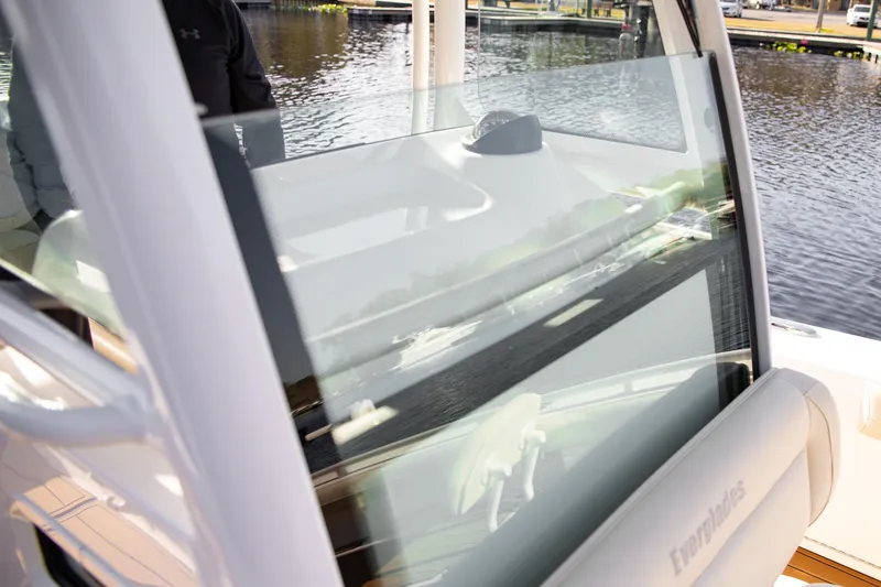 Slide: The Image of 2017 Everglades 253 Center Console boat windshield and seating detail by the water. - 13