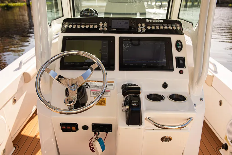 Slide: The Image of 2017 Everglades 253 Center Console boat dashboard with steering wheel and navigation controls. - 15