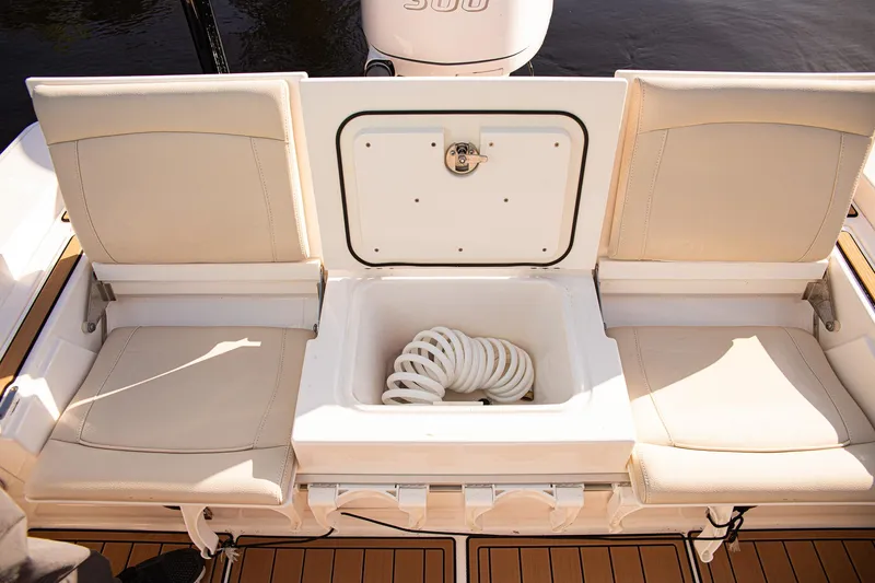 Slide: The Image of 2017 Everglades 253 Center Console boat seating with storage compartment and coiled rope. - 26