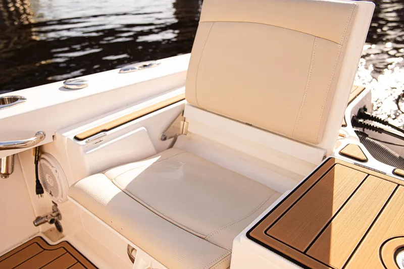 Slide: The Image of 2017 Everglades 253 Center Console boat seat with beige upholstery and wood accents. - 29