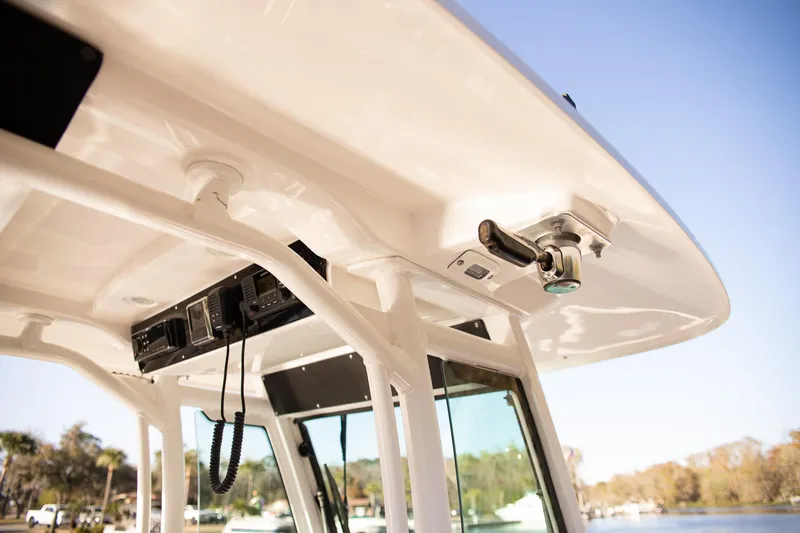 Slide: The Image of 2017 Everglades 253 Center Console boat, featuring a sturdy T-top and electronic equipment. - 39