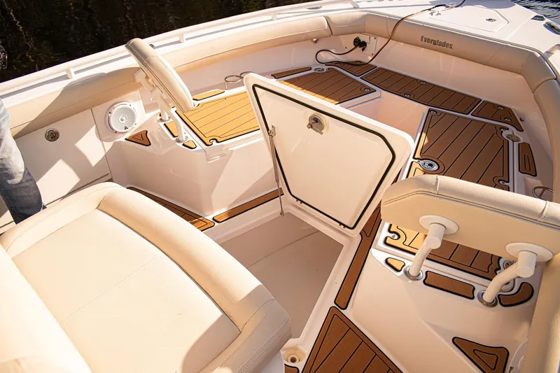 Slide: The Image of 2017 Everglades 253 Center Console boat interior with open storage compartment and cushioned seating. - 7