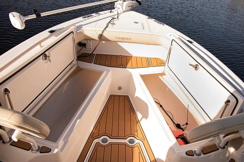 Slide: The Image of 2017 Everglades 253 Center Console boat interior with open storage compartments and wood flooring. - 8