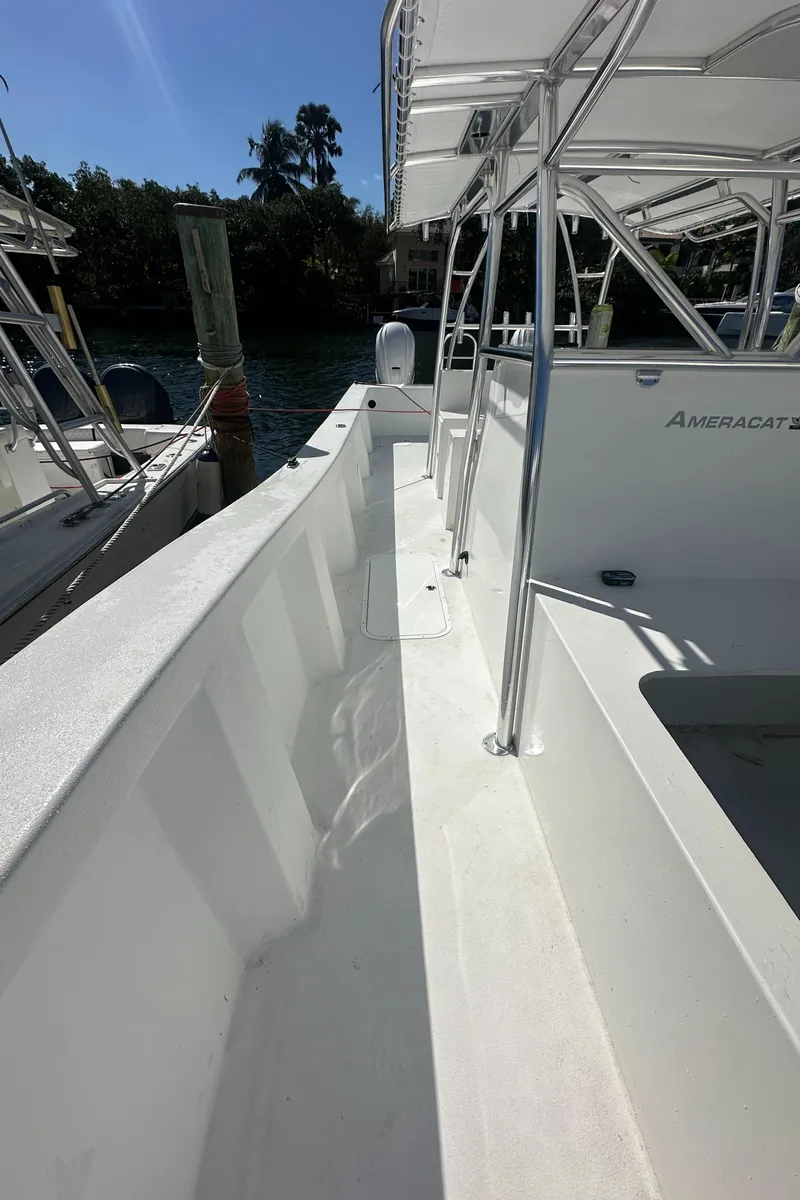Slide: The Image of 2025 AmeraCat 395 boat, sleek white deck, docked near lush greenery. - 16