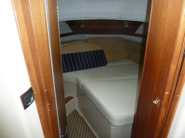 Slide: The Image of 2013 Ranger Tugs R-31 cabin interior with cozy bed and wooden accents. - 13