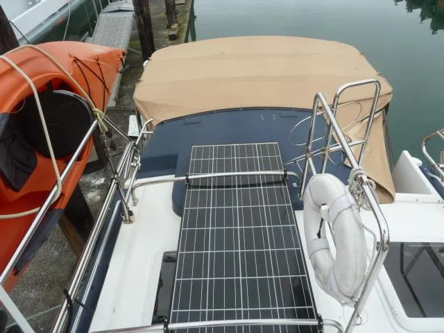 Slide: The Image of 2013 Ranger Tugs R-31 boat with solar panels and beige canopy, docked near water. - 16