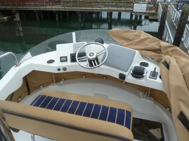 Slide: The Image of 2013 Ranger Tugs R-31 helm with steering wheel, navigation equipment, and seating. - 17