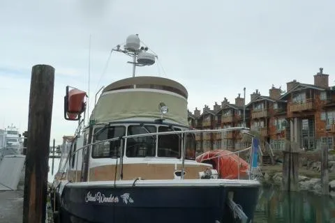 Slide: The Image of 2013 Ranger Tugs R-31 boat docked near rustic waterfront buildings. - 25