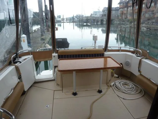 Slide: The Image of 2013 Ranger Tugs R-31 boat interior with table, docked at marina. - 4