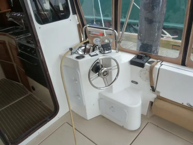 Slide: The Image of 2013 Ranger Tugs R-31 helm station with steering wheel and navigation controls. - 5