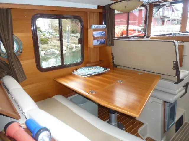 Slide: The Image of Interior of 2013 Ranger Tugs R-31 with wooden table and seating area. - 7