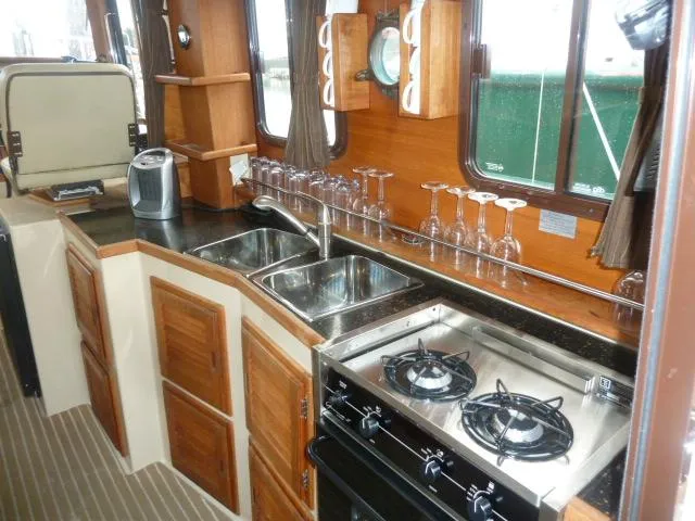 Slide: The Image of Interior of 2013 Ranger Tugs R-31 boat kitchen with stove, sink, and wooden cabinets. - 8