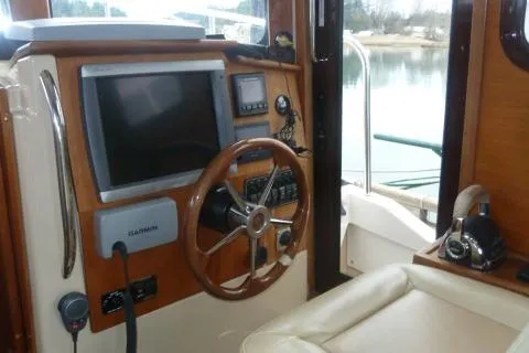 Slide: The Image of 2013 Ranger Tugs R-31 helm with steering wheel, navigation equipment, and comfortable seating. - 9