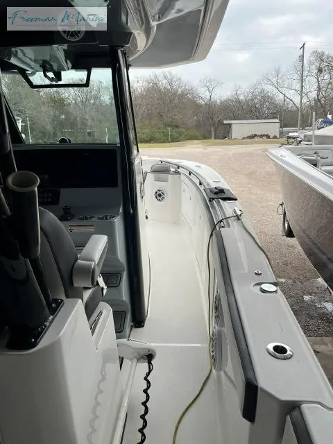 Slide: The Image of 2022 Crevalle 33 CSF boat interior with console and seating, docked outdoors. - 13